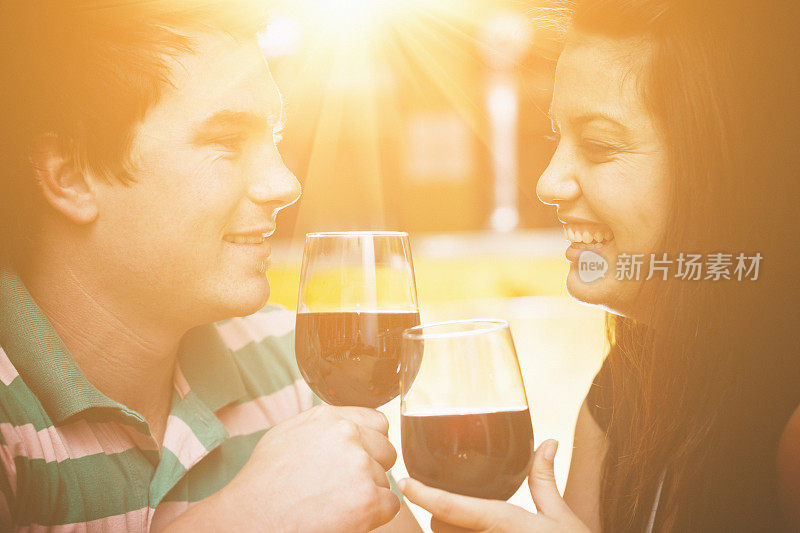 浪漫的年轻情侣互相祝酒，微笑，梦幻般的温柔焦点。