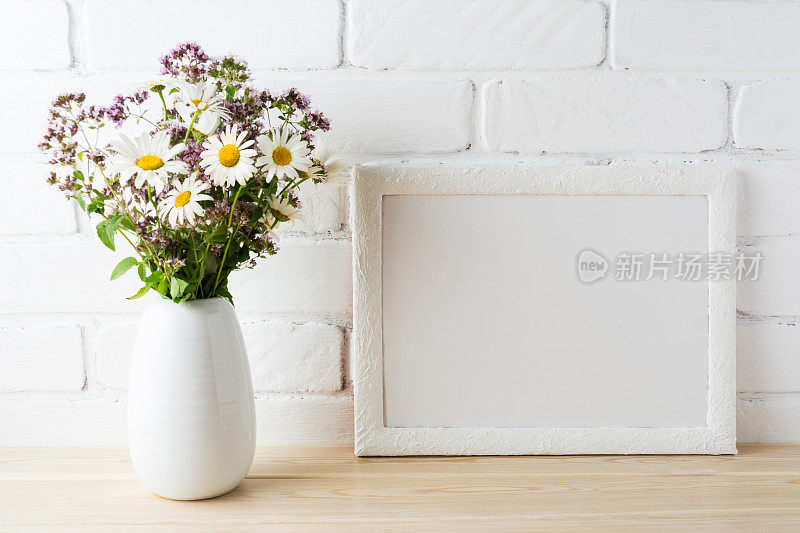 白色景观框架模型与盛开的野花花束在花瓶