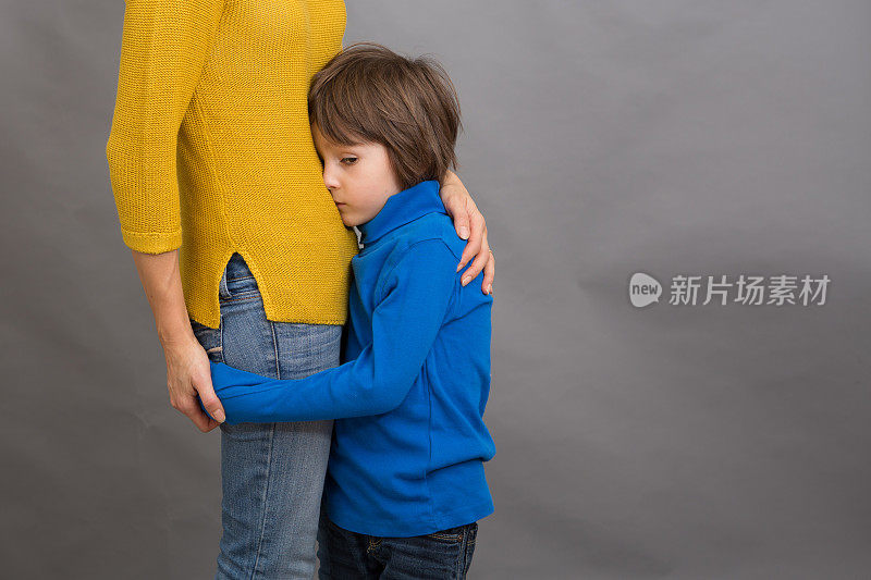 伤心的小男孩，抱着妈妈在家，孤立的形象，复制空间。家庭的概念