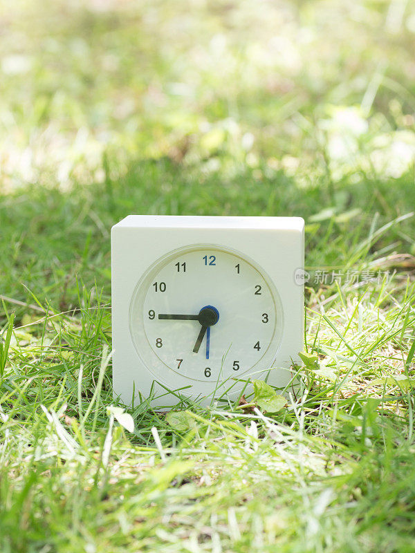 草坪上的白色简单时钟，6:45六点四十五分