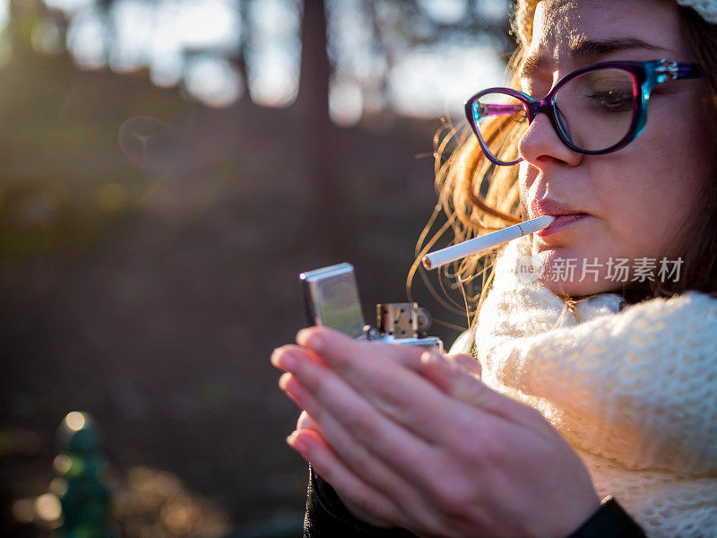 一个吸烟上瘾的女孩试图点燃一支香烟的特写镜头