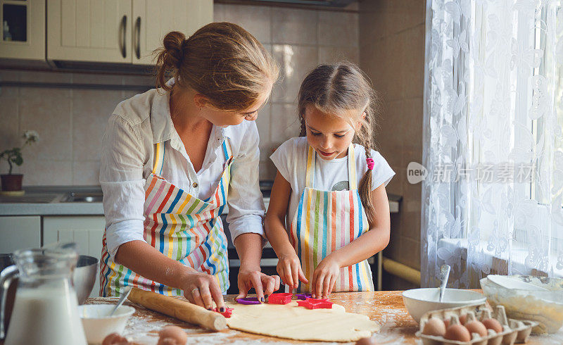 幸福的家庭妈妈和女儿在厨房烤面团