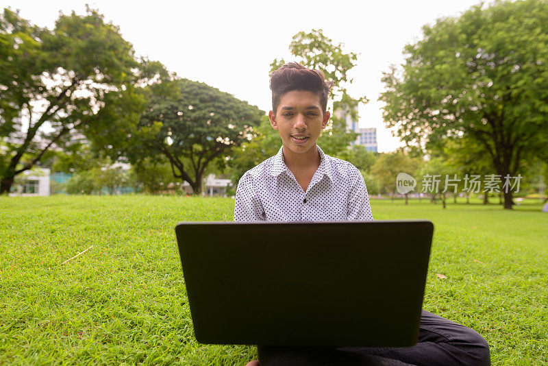 年轻英俊的印度男孩在泰国曼谷的朗菲尼公园放松的肖像