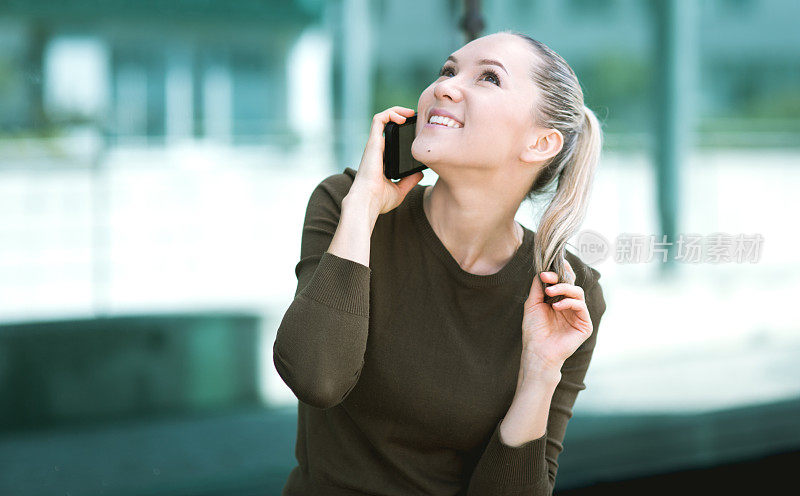 美丽的年轻女子在现实生活中使用智能手机