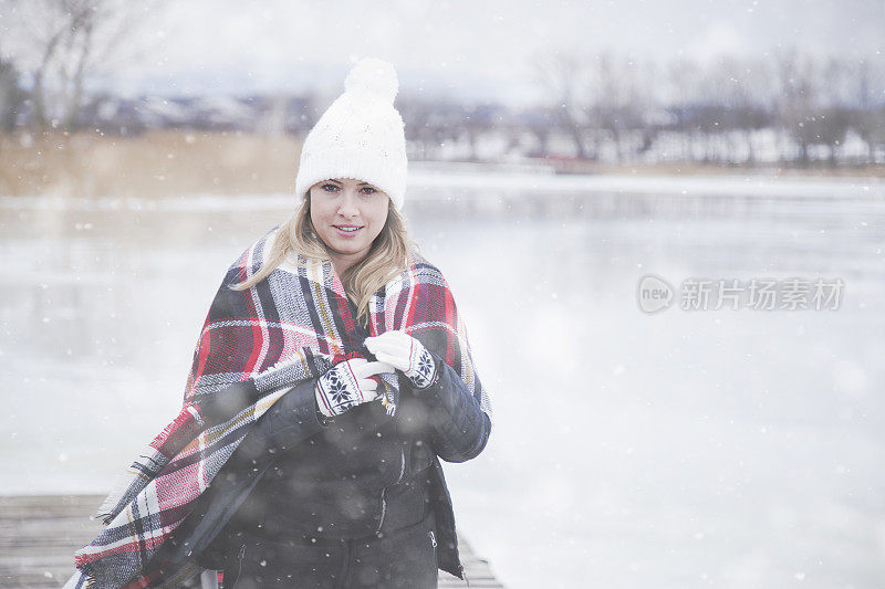 雪地里穿着格子毯子的年轻女子