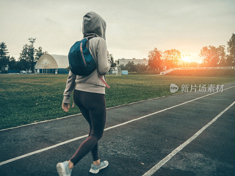 在体育场跑道上跑步的女人