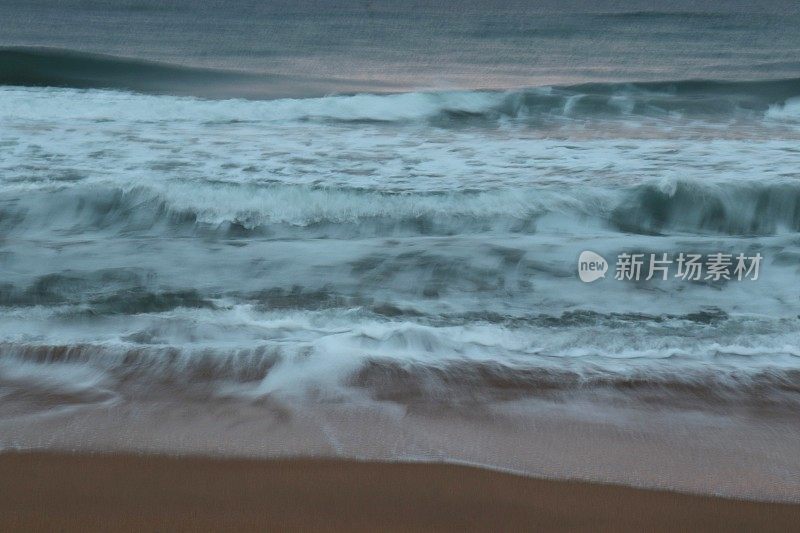 日出时海浪涌上海滩