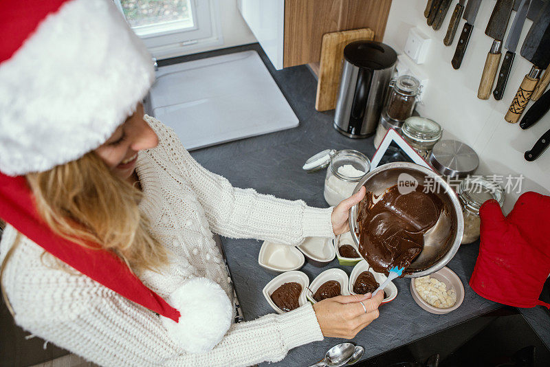 女人烹饪巧克力蛋糕浇巧克力成心形，自制食物-圣诞节时间