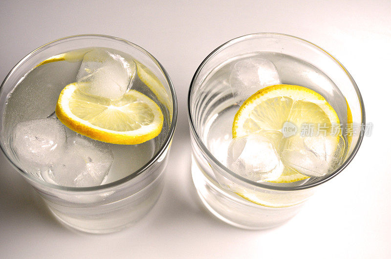 两个透明玻璃杯，装有无色液体-水，酒精