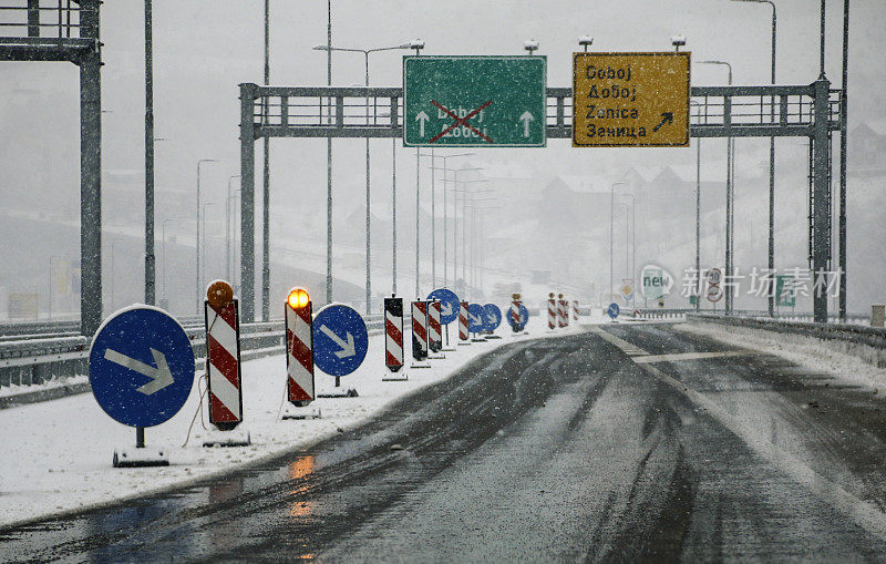 下雪天的高速公路上有警告标志