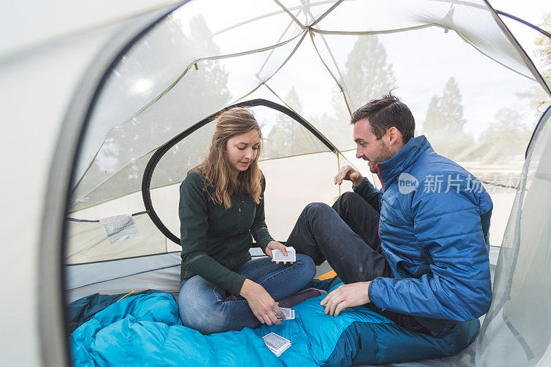 一对年轻夫妇在他们的帐篷里打牌