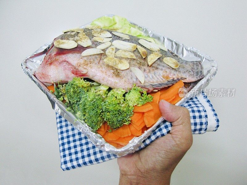 托盘上放着烤尼罗罗非鱼和蔬菜
