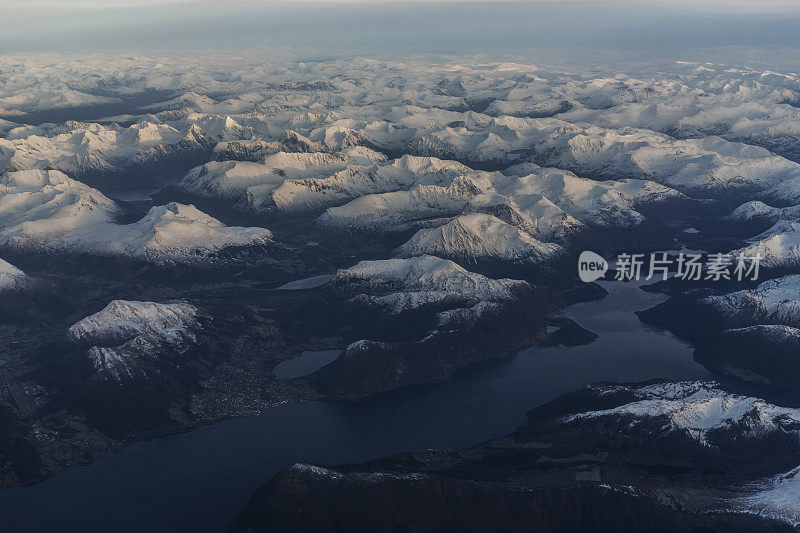 乘客从飞机上俯瞰挪威的峡湾，山上覆盖着积雪