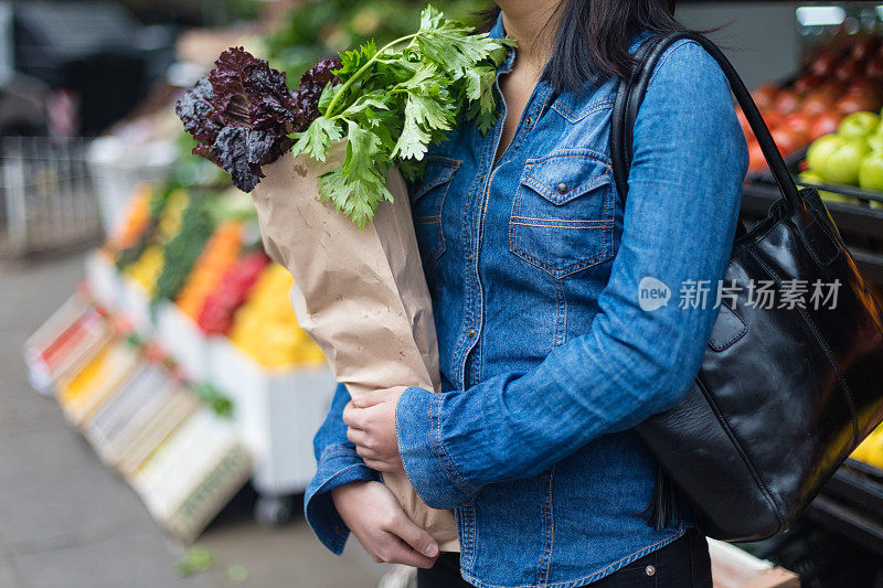 亚洲妇女在蔬菜水果店与一袋蔬菜