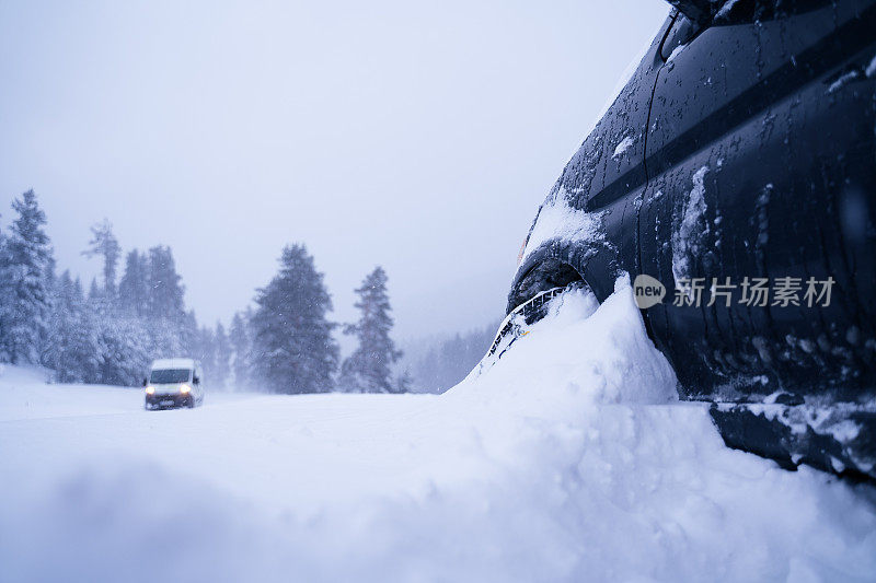 在雪下。车POV，行驶在积雪覆盖的道路上，初雪霏霏。