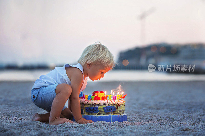 可爱的男孩们，在海滩上庆祝生日，有汽车主题的蛋糕和装饰