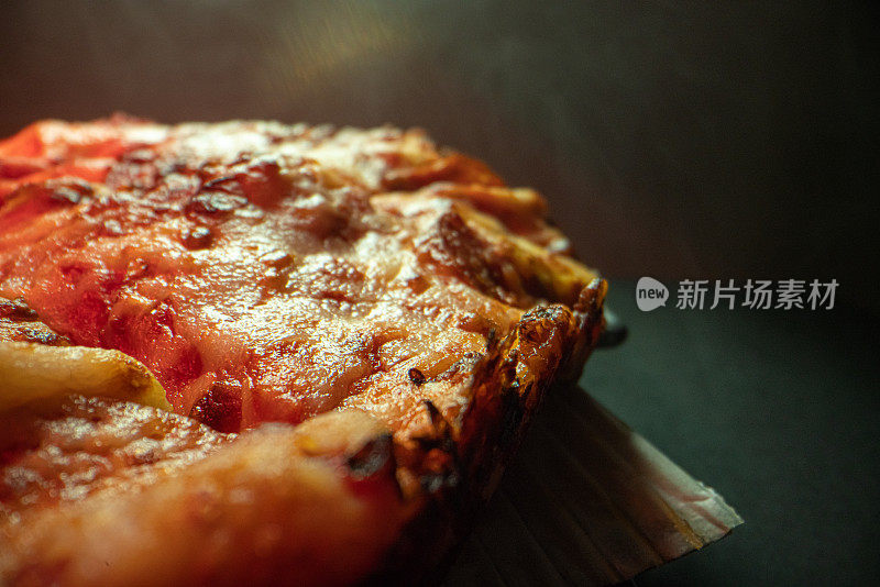 特写广角拍摄的美味烧焦的外壳上热气腾腾的深盘辣香肠披萨新鲜出炉的烤箱在冷却架下的加热灯与复制空间