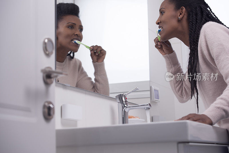 在浴室刷牙的女人。