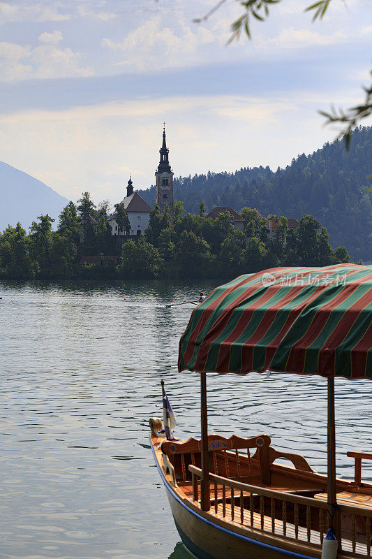 斯洛文尼亚的布雷德湖上的pletna船，背景是欧洲的阿尔卑斯山