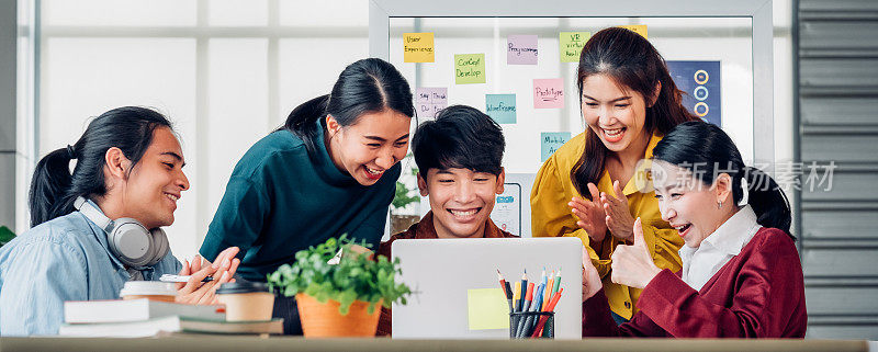 亚洲用户体验开发和ui设计师看笔记本电脑屏幕的成功设计批准在现代办公室。创意数字发展机构