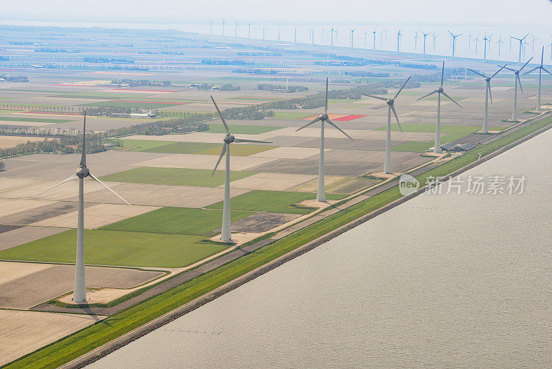 荷兰鸟瞰图中，风力涡轮机前是春天盛开的郁金香田