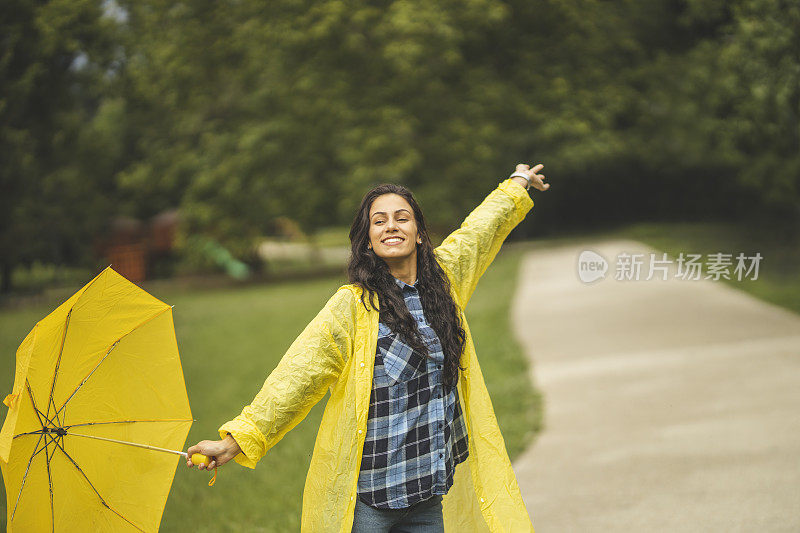 快乐的女人微笑着行走在雨天