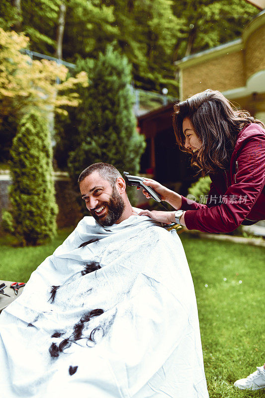 女朋友在后院剪微笑男人的头发