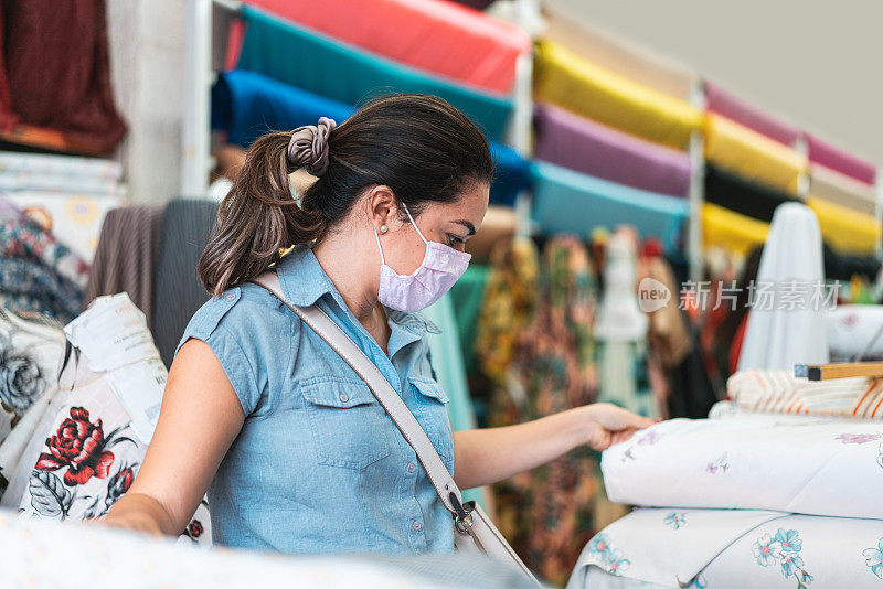 在布料店戴着防护面具的女人