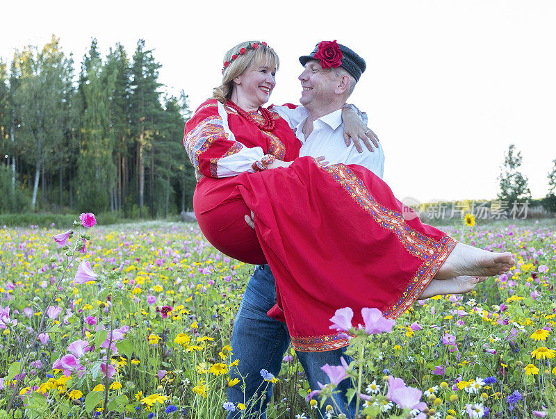 男人把女人抱在怀里。一对结婚40年的夫妇。一个男人和一个女人穿着民族服装的白俄罗斯，乌克兰，俄罗斯。