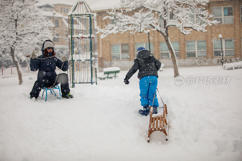 妈妈和儿子在公园玩雪橇