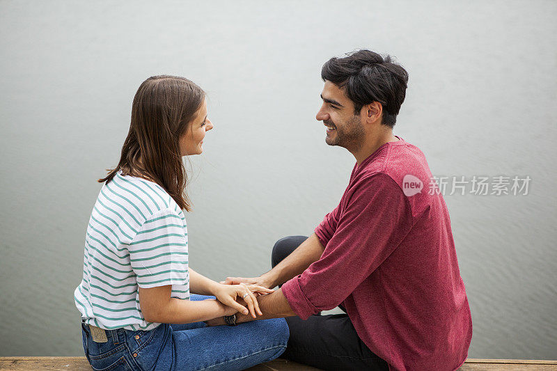 一对夫妇坐在湖边