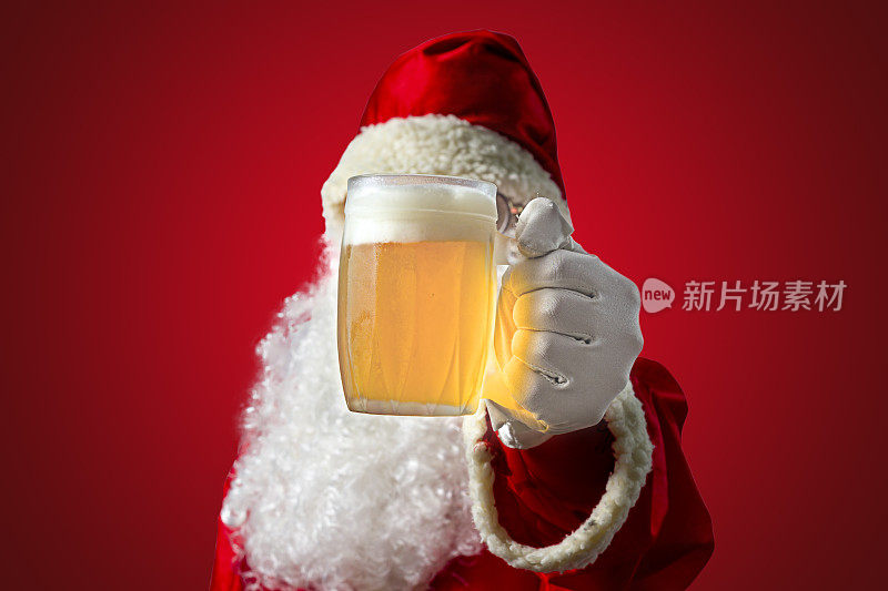 圣诞老人和一大杯啤酒。彩色背景和选择性对焦