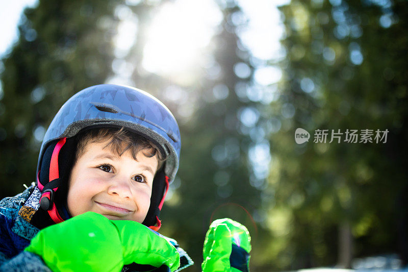 一个快乐的小男孩等着去滑雪