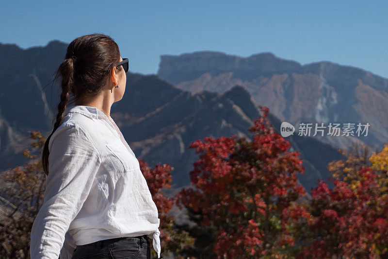 一位戴着黑色太阳镜的年轻女子非常欣赏岩石嶙峋的山顶
