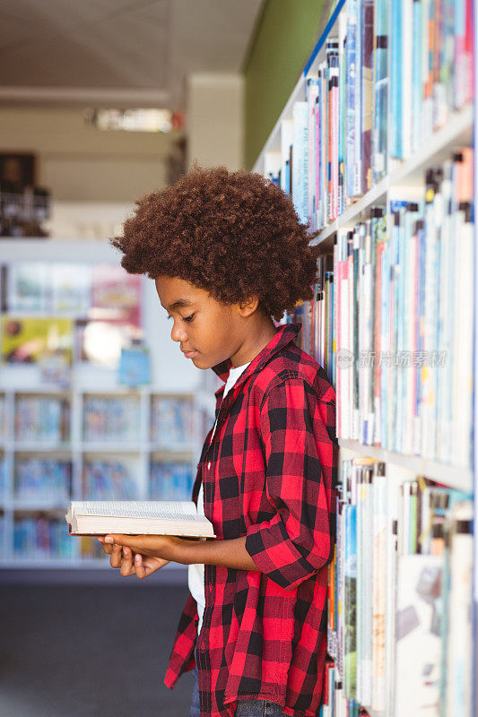 快乐的非裔美国学生站在学校图书馆看书