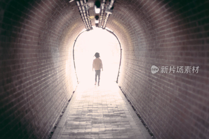 一个女孩在隧道里走向光明