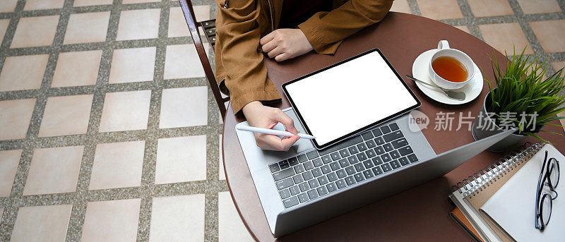 女性远程工作，使用笔记本电脑和平板电脑。
