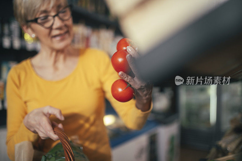 一个女人拿着番茄的特写。