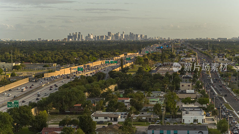 在黄昏时分，遥望迈阿密市中心，俯瞰北迈阿密金色空地的居民区。大街上和高速公路上的交通高峰时间。