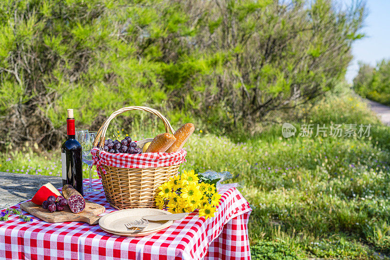 野餐篮，外面的桌布上放着食物和酒