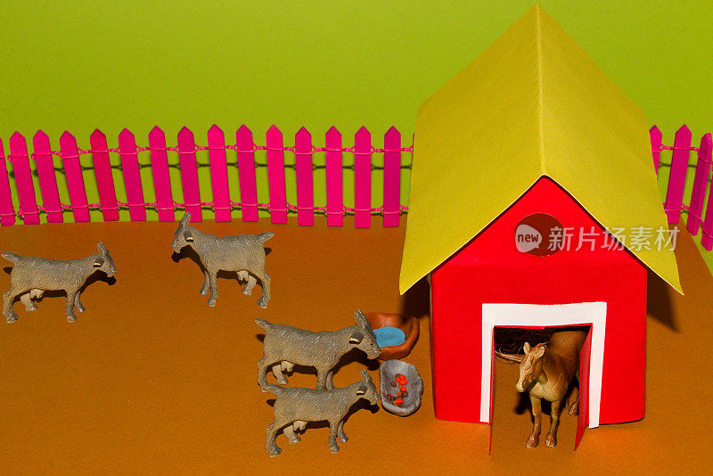 山羊和马围绕着陈旧的纸的创意概念村庄