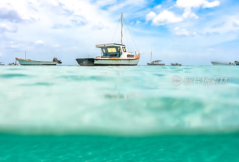 在Curaçao的泻湖上漂浮着渔船，还有风景优美的蓝绿色海水和航海船只