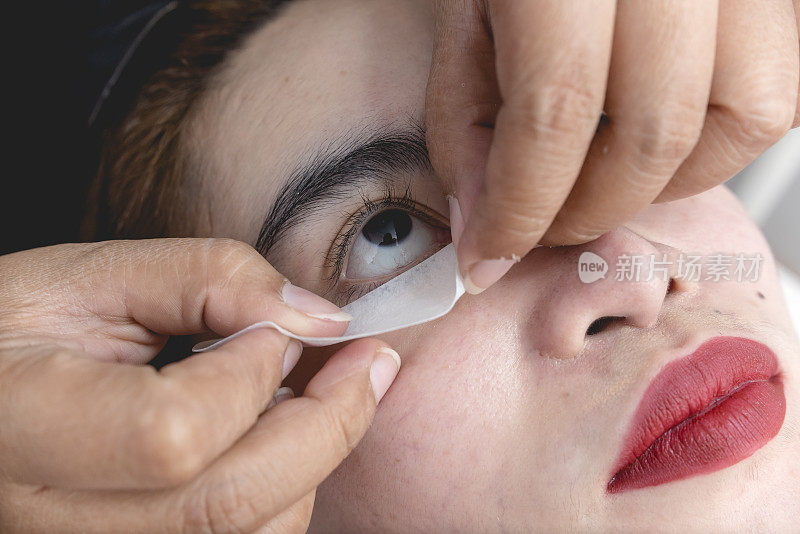 美容师将眼垫放在客户的下睫毛下方。准备睫毛延长程序。