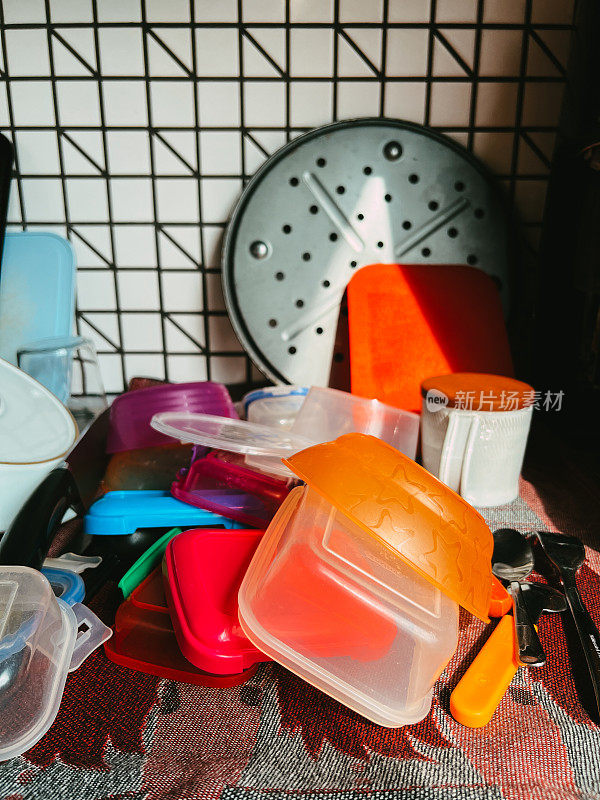 厨房柜台上堆放着干净的盘子和保鲜盒