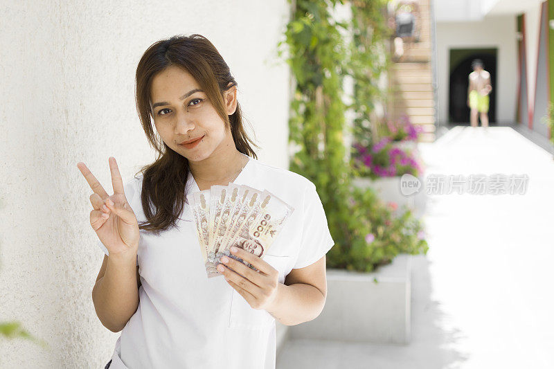 幸福的亚洲女人手里拿着钞票