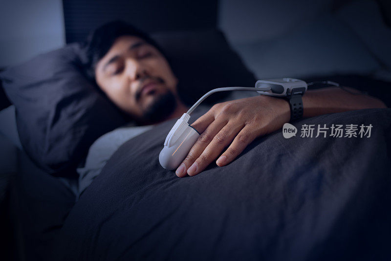 男子戴着脉搏血氧计-在家睡眠研究测试睡眠呼吸暂停