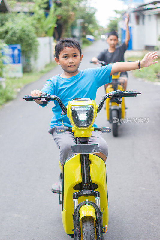 男孩在小区骑着电动车，一起出去玩