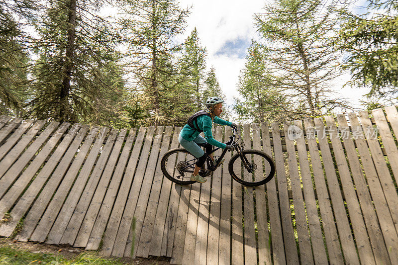 女子山地自行车骑在垂直木坡道在自行车公园