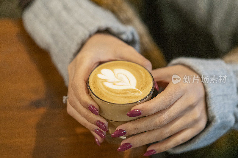 拿铁咖啡就是那个女孩拿在手里的