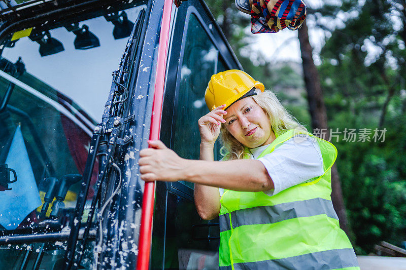 图为一名在建筑工地工作的女挖掘机司机